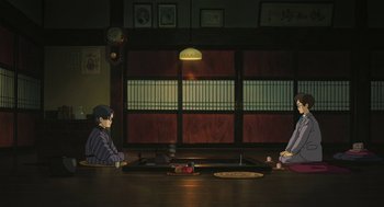 Movie still from “The Wind Rises” (2013), directed by Hayao Miyazaki – Two people sitting at a table in front of an open window; Wide shot, High angle