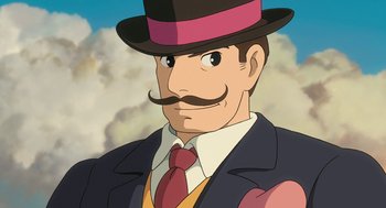 Movie still from “The Wind Rises” (2013), directed by Hayao Miyazaki – An animated man with a mustache wearing a suit and a hat; Close Up shot, Low angle