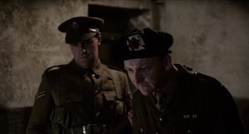 Movie still from “The Wind that Shakes the Barley” (2006), directed by Ken Loach – A couple of men in military uniforms standing next to each other; Medium shot, Over the shoulder angle