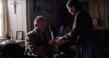 Movie still from “The Wind that Shakes the Barley” (2006), directed by Ken Loach – A man and a woman are holding a cell phone; Medium shot, Over the shoulder angle