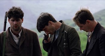 Movie still from “The Wind that Shakes the Barley” (2006), directed by Ken Loach – A man in a brown jacket is talking on a cell phone; Close Up shot, Over the shoulder angle
