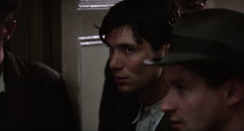 Movie still from “The Wind that Shakes the Barley” (2006), directed by Ken Loach – A person wearing a suit and hat; Close Up shot, Over the shoulder angle