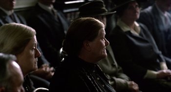 Movie still from “The Wind that Shakes the Barley” (2006), directed by Ken Loach – An older woman sitting in a crowd of people; Close Up shot, Over the shoulder angle