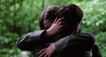Movie still from “The Wind that Shakes the Barley” (2006), directed by Ken Loach – A man and a woman hugging in the woods; Close Up shot, Over the shoulder angle
