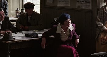 Movie still from “The Wind that Shakes the Barley” (2006), directed by Ken Loach – An older woman sitting in front of a man; Medium shot, Over the shoulder angle