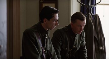 Movie still from “The Wind that Shakes the Barley” (2006), directed by Ken Loach – A couple of men sitting next to each other in military uniforms; Medium shot, Low angle
