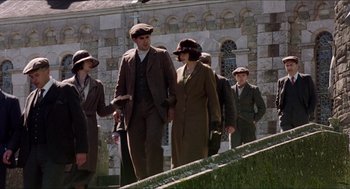 Movie still from “The Wind that Shakes the Barley” (2006), directed by Ken Loach – A group of people standing next to each other on stairs; Medium shot, Low angle