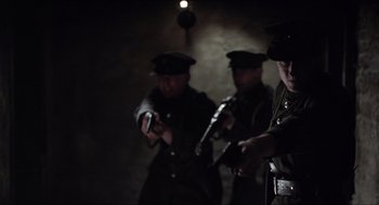 Movie still from “The Wind that Shakes the Barley” (2006), directed by Ken Loach – A group of men standing next to each other holding guns; Medium shot, Low angle