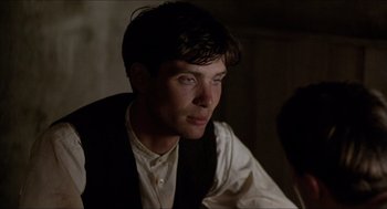 Movie still from “The Wind that Shakes the Barley” (2006), directed by Ken Loach – A man in a vest and tie looking to his left; Close Up shot, Over the shoulder angle