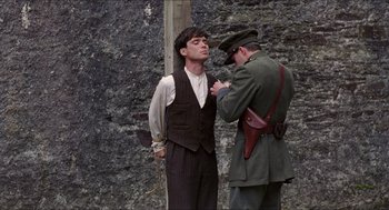 Movie still from “The Wind that Shakes the Barley” (2006), directed by Ken Loach – A man in a suit and a man in a military uniform; Medium shot, Over the shoulder angle