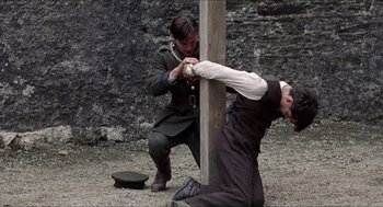 Movie still from “The Wind that Shakes the Barley” (2006), directed by Ken Loach – Two men in uniform are playing a game of tug - o - war; Medium shot, Low angle