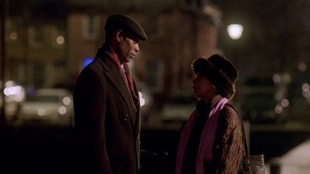Movie still from “The Wire” (2002), created by David Simon – A man and a woman standing next to each other on a street; Medium shot, Low angle