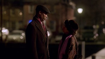 Movie still from “The Wire” (2002), created by David Simon – A man and a woman standing next to each other on a street; Medium shot, Over the shoulder angle