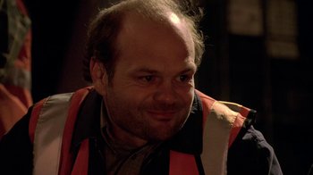 Movie still from “The Wire” (2002), created by David Simon – A person wearing an orange vest; Close Up shot, Over the shoulder angle