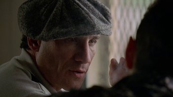 Movie still from “The Wire” (2002), created by David Simon – A person wearing a hat; Close Up shot, Over the shoulder angle