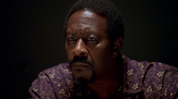 Movie still from “The Wire” (2002), created by David Simon – A person wearing a purple shirt; Close Up shot, Low angle