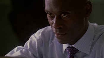 Movie still from “The Wire” (2002), created by David Simon – A person wearing a shirt and tie; Close Up shot, High angle