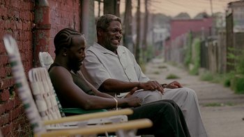 Movie still from “The Wire” (2002), created by David Simon – Two men sitting on a bench talking to each other; Medium shot, High angle