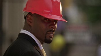 Movie still from “The Wire” (2002), created by David Simon – A person wearing a hard hat; Close Up shot, Low angle