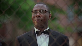 Movie still from “The Wire” (2002), created by David Simon – A man in a suit and a bow tie; Close Up shot, Low angle