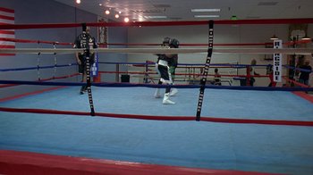 Movie still from “The Wire” (2002), created by David Simon – Two people are boxing in a boxing ring; Extreme Wide shot, High angle