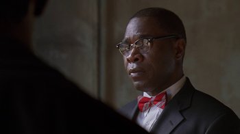Movie still from “The Wire” (2002), created by David Simon – A man in a suit and a red bow tie; Close Up shot, Over the shoulder angle