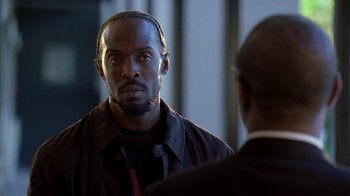 Movie still from “The Wire” (2002), created by David Simon – A man with a beard is talking to another man; Close Up shot, Over the shoulder angle