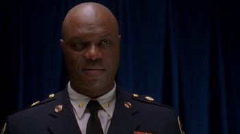 Movie still from “The Wire” (2002), created by David Simon – A man in a military uniform is looking straight ahead; Close Up shot, Low angle