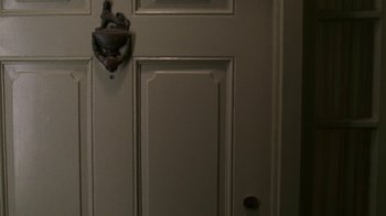 Movie still from “The Wire” (2002), created by David Simon – The door of a house has a door knocker on it's side; Extreme Close Up shot, High angle