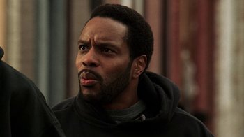 Movie still from “The Wire” (2002), created by David Simon – A person wearing a hoodie; Close Up shot, Low angle