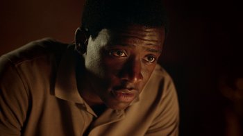 Movie still from “Snowfall” (2017), directed by Hiro Murai – A person wearing a brown shirt; Close Up shot, High angle