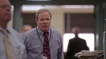 Movie still from “The Wire” (2002), created by David Simon – An older man wearing a red and blue striped tie; Close Up shot, Low angle