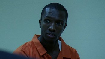 Movie still from “The Wire” (2002), created by David Simon – A person wearing an orange shirt; Close Up shot, Low angle