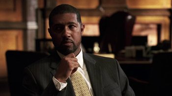 Movie still from “The Wire” (2002), created by David Simon – A man in a suit and a yellow tie; Close Up shot, Low angle