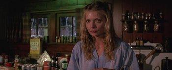 Movie still from “The Witches of Eastwick” (1987), directed by George Miller – A woman standing in front of a bar with bottles; Close Up shot, Low angle