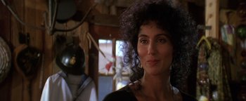 Movie still from “The Witches of Eastwick” (1987), directed by George Miller – A person wearing a black shirt; Close Up shot, Over the shoulder angle