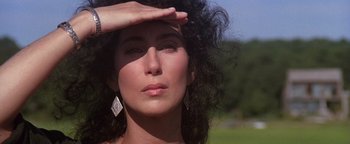 Movie still from “The Witches of Eastwick” (1987), directed by George Miller – A person with a hand on her forehead; Close Up shot, Low angle