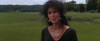 Movie still from “The Witches of Eastwick” (1987), directed by George Miller – A woman with curly hair and a necklace; Close Up shot, Over the shoulder angle