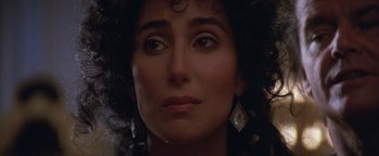 Movie still from “The Witches of Eastwick” (1987), directed by George Miller – A woman's face in a dark room; Close Up shot, Over the shoulder angle