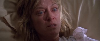 Movie still from “The Witches of Eastwick” (1987), directed by George Miller – A person with blue eyes and blonde hair; Close Up shot, Low angle