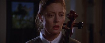 Movie still from “The Witches of Eastwick” (1987), directed by George Miller – A person holding a cello; Close Up shot, Over the shoulder angle