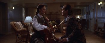 Movie still from “The Witches of Eastwick” (1987), directed by George Miller – A man and a woman are playing the cello together; Medium shot, Over the shoulder angle
