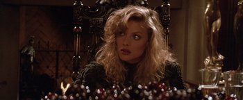 Movie still from “The Witches of Eastwick” (1987), directed by George Miller – A person sitting in a chair; Close Up shot, Over the shoulder angle