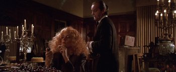 Movie still from “The Witches of Eastwick” (1987), directed by George Miller – A man and a woman in a dark room; Medium shot, Low angle