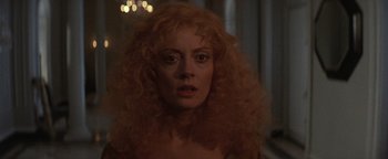 Movie still from “The Witches of Eastwick” (1987), directed by George Miller – A person with curly hair; Close Up shot, Over the shoulder angle