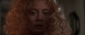 Movie still from “The Witches of Eastwick” (1987), directed by George Miller – A person with curly hair; Close Up shot, Over the shoulder angle