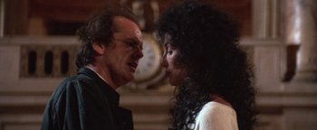 Movie still from “The Witches of Eastwick” (1987), directed by George Miller – A man and a woman face to face in front of a clock; Close Up shot, Over the shoulder angle