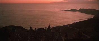 Movie still from “The Witches of Eastwick” (1987), directed by George Miller – A view of the ocean from above at sunset; Extreme Wide shot, High angle