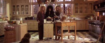 Movie still from “The Witches of Eastwick” (1987), directed by George Miller – A group of women standing around a table; Medium shot, High angle