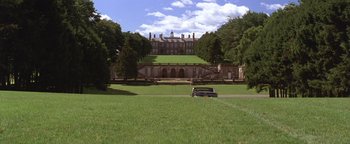 Movie still from “The Witches of Eastwick” (1987), directed by George Miller – A car is parked in front of a large mansion; Extreme Wide shot, Low angle